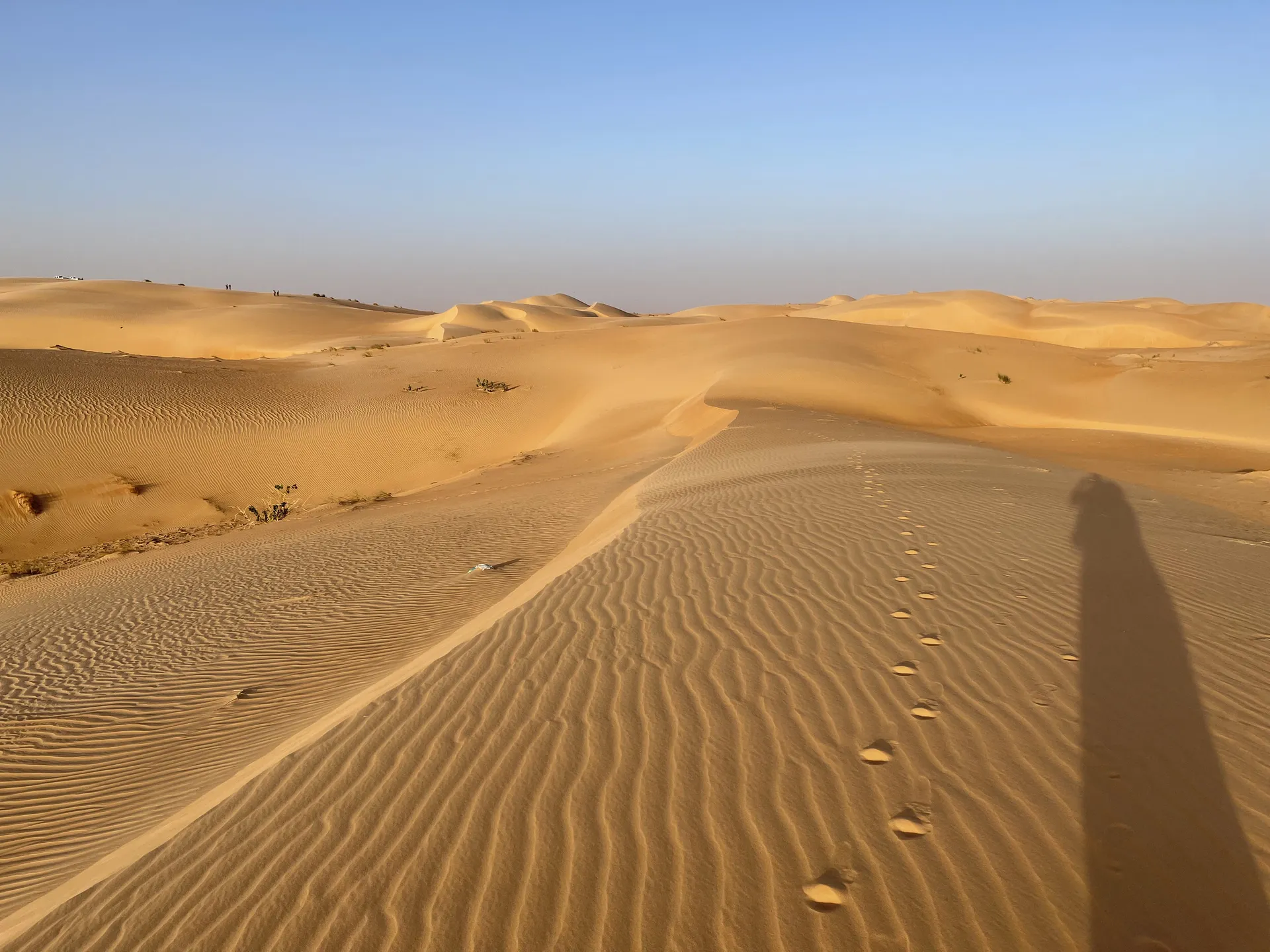 Footprints and long shadows across sand dunes near Chinguetti