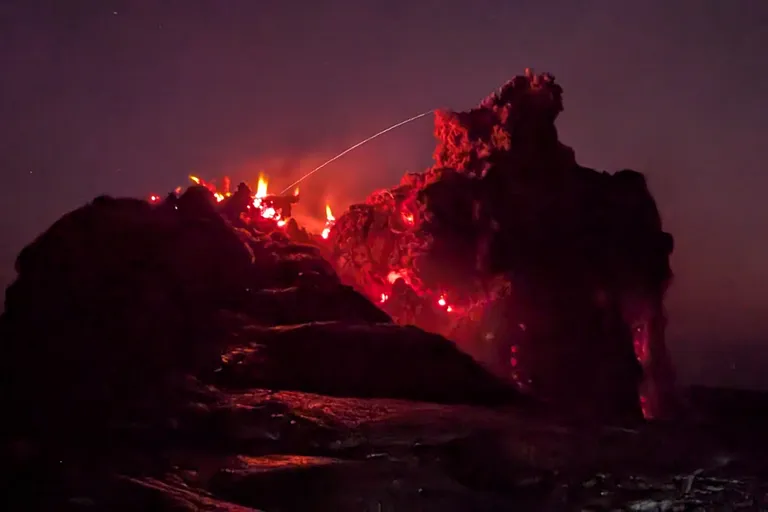 Glowing red lava at the summit of the Erta Ale volcano at night in the Danakil Depression