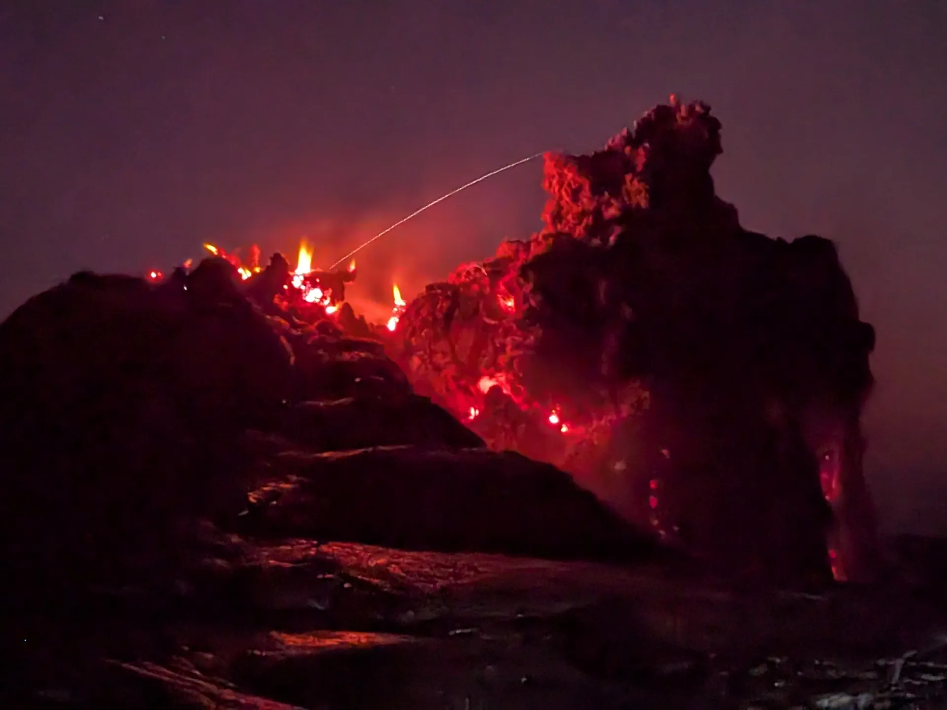 Glowing red lava at the summit of the Erta Ale volcano at night in the Danakil Depression
