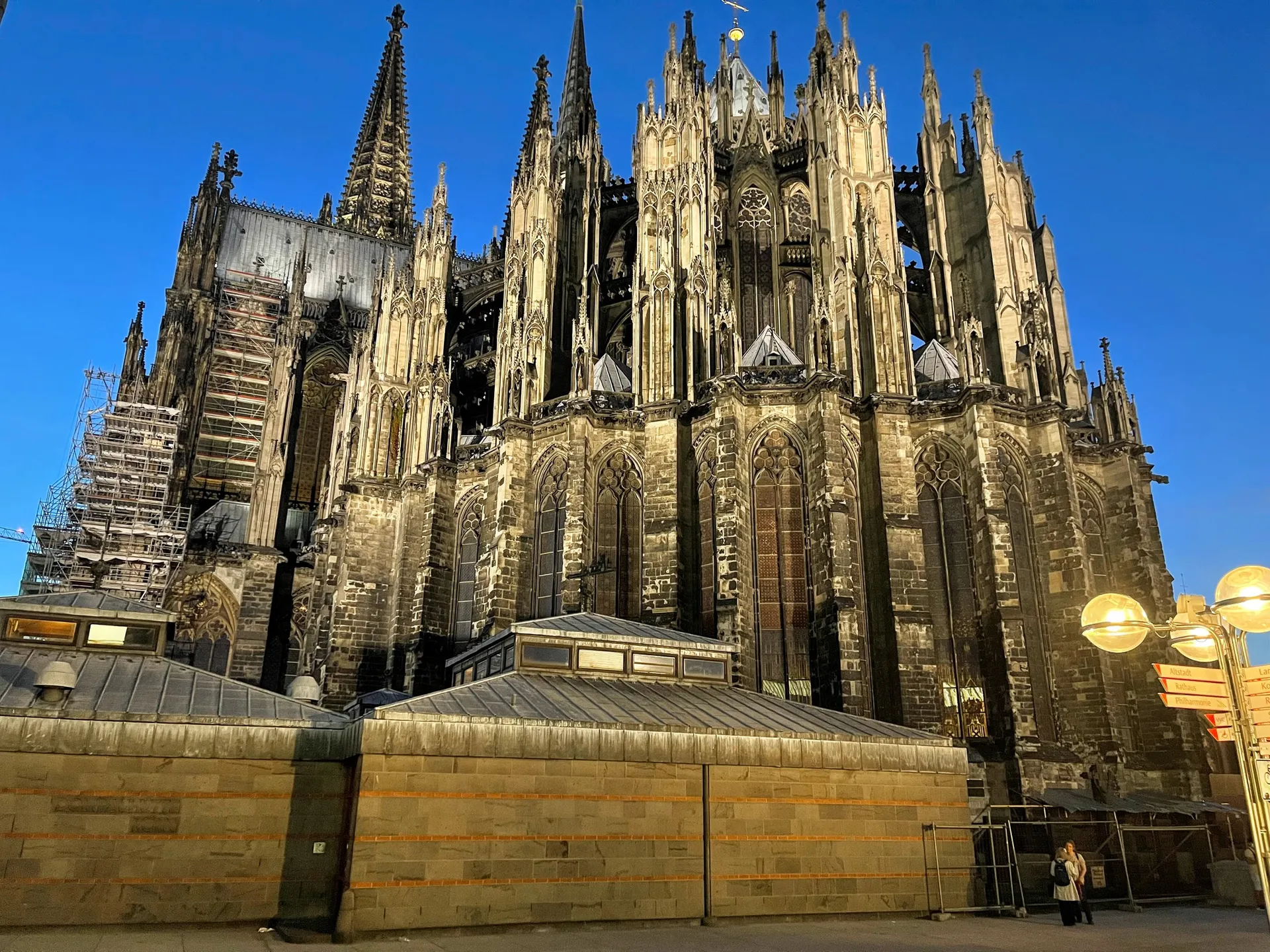 The Gothic east end of Cologne Cathedral (Kölner Dom) with its twin spires and flying buttresses against a deep blue evening sky
