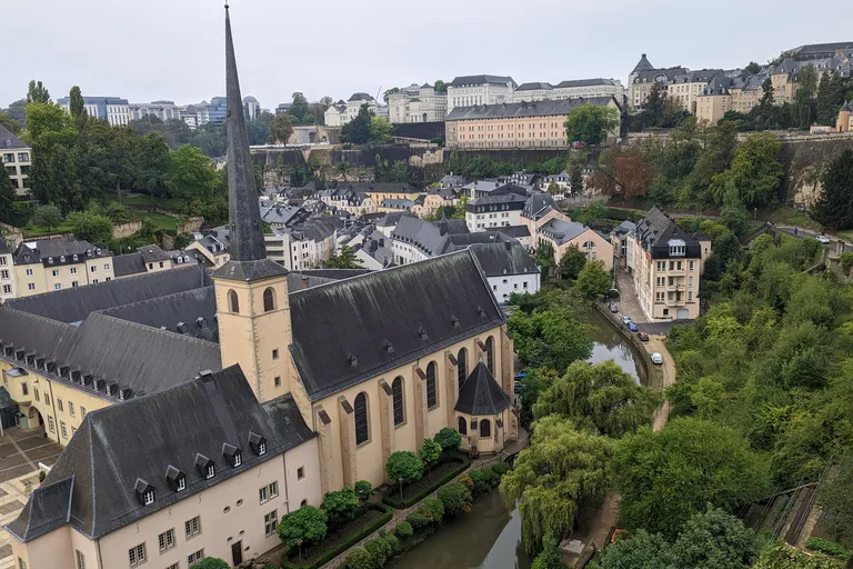 View over the Grund with sandstone fortress cliffs, the Alzette river, and the spire of Neumünster Abbey in Luxembourg City