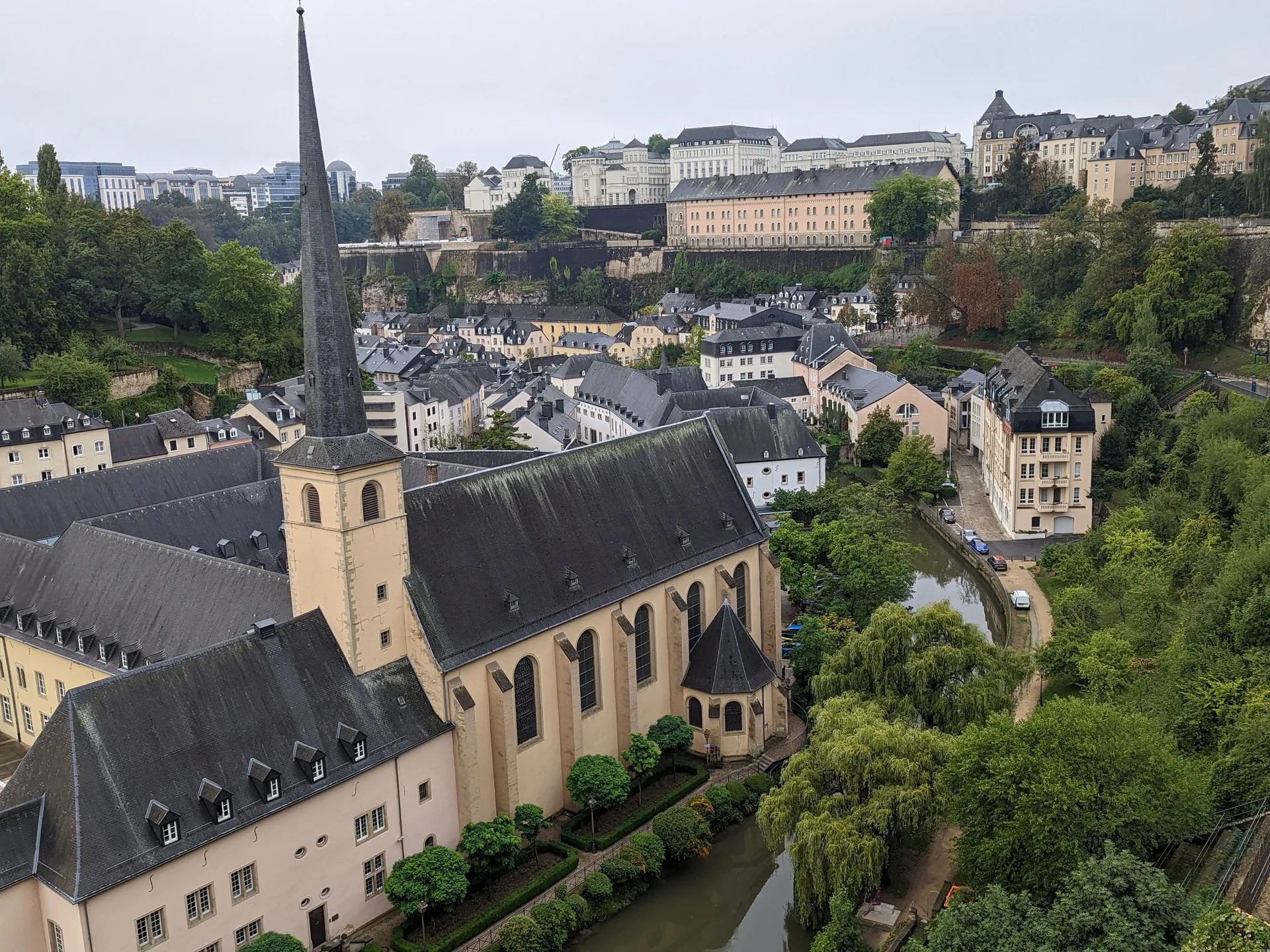 View over the Grund with sandstone fortress cliffs, the Alzette river, and the spire of Neumünster Abbey in Luxembourg City