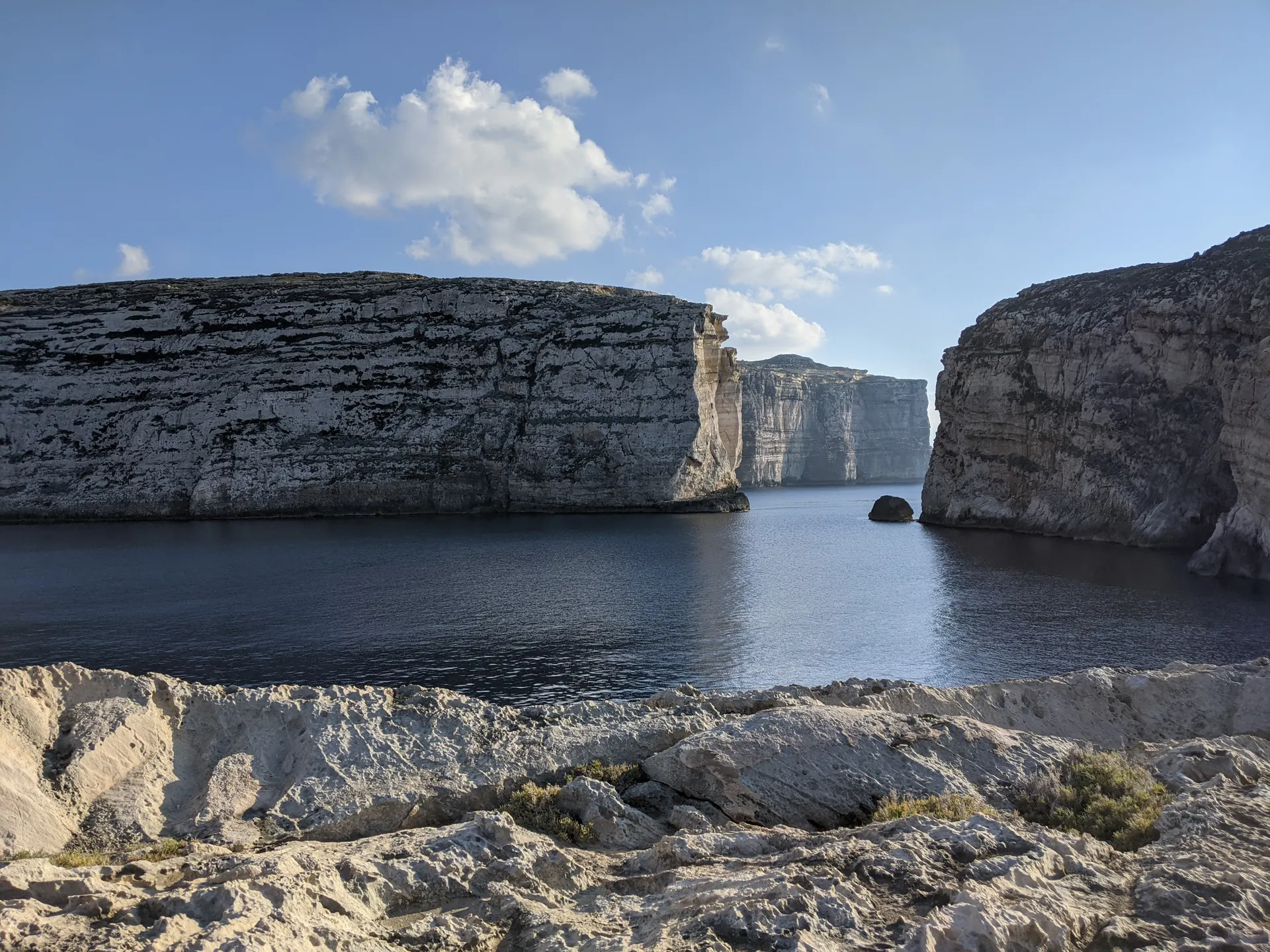 Limestone sea cliffs and blue water on the coast of Malta