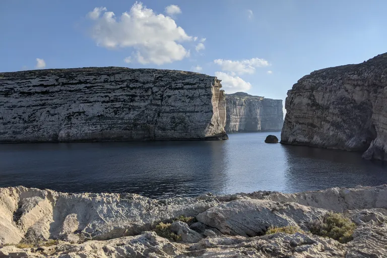 Limestone sea cliffs and blue water on the coast of Malta