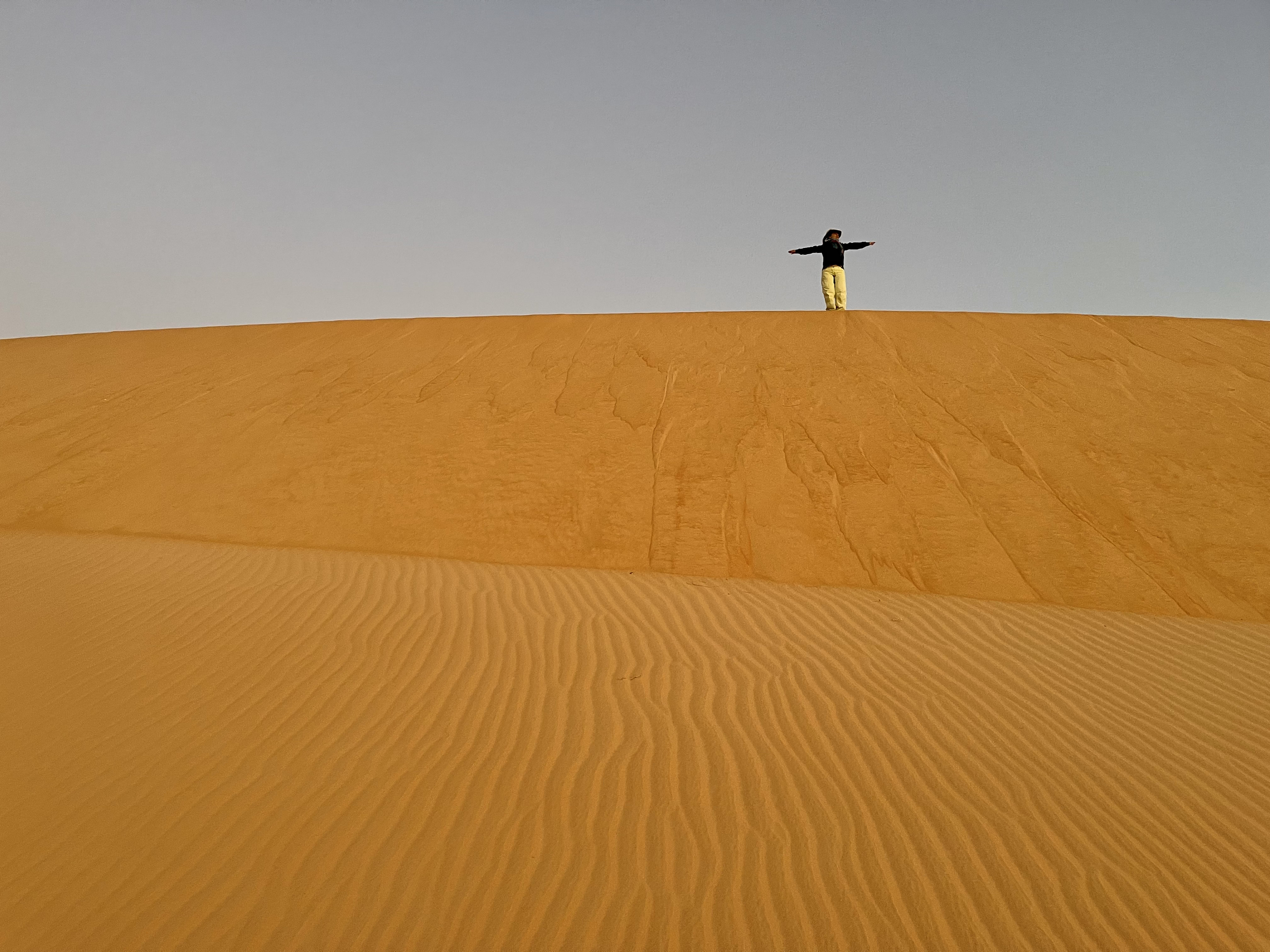 Traveller standing on top of a Saharan sand dune near Chinguetti