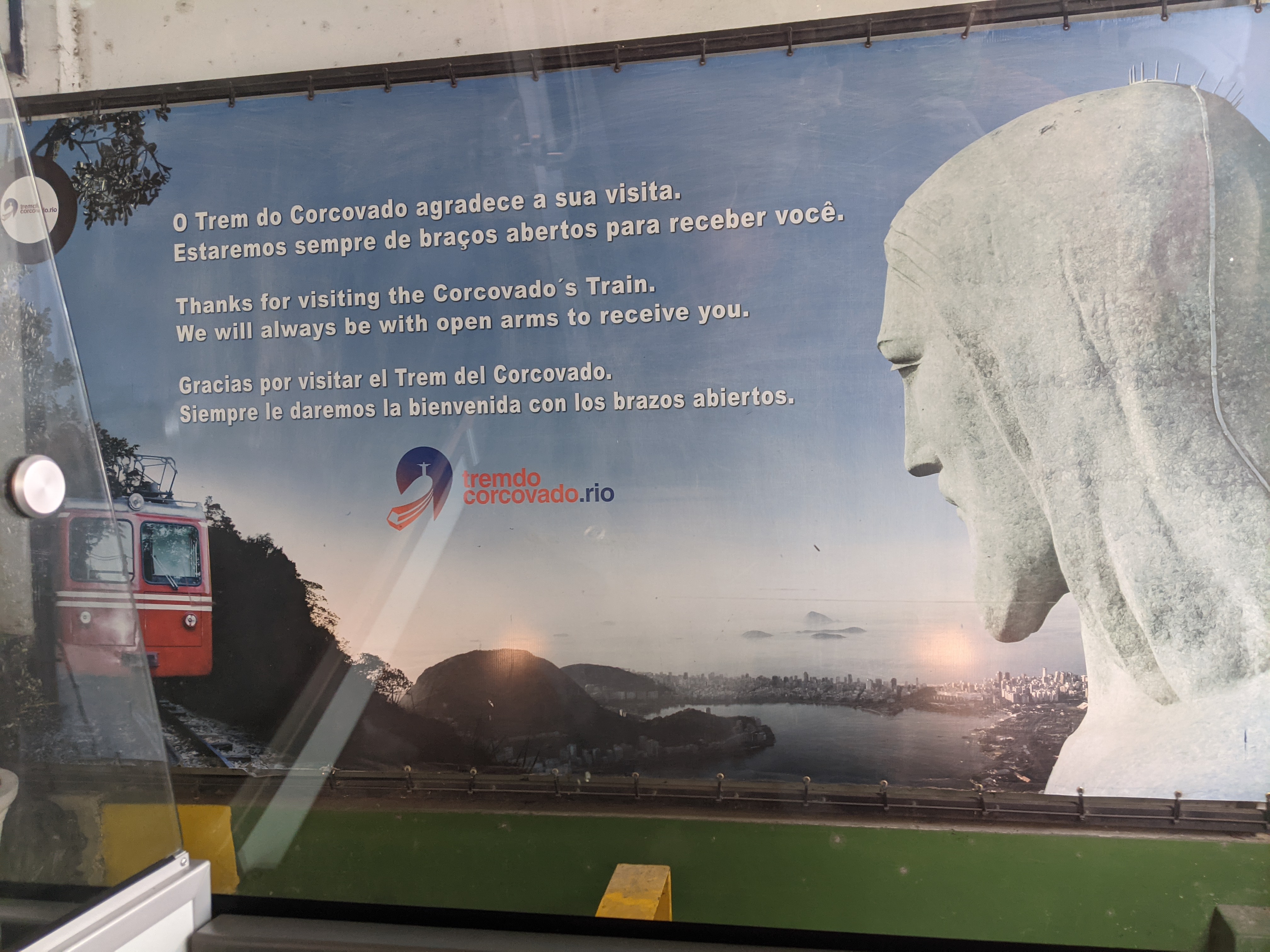 Sign for the Trem do Corcovado showing the red cog train and the Christ the Redeemer statue