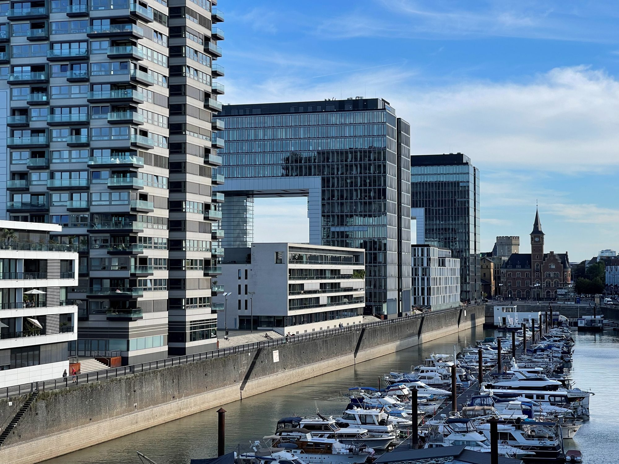 Modern crane-shaped Kranhäuser buildings and a marina of boats at Cologne's Rheinauhafen