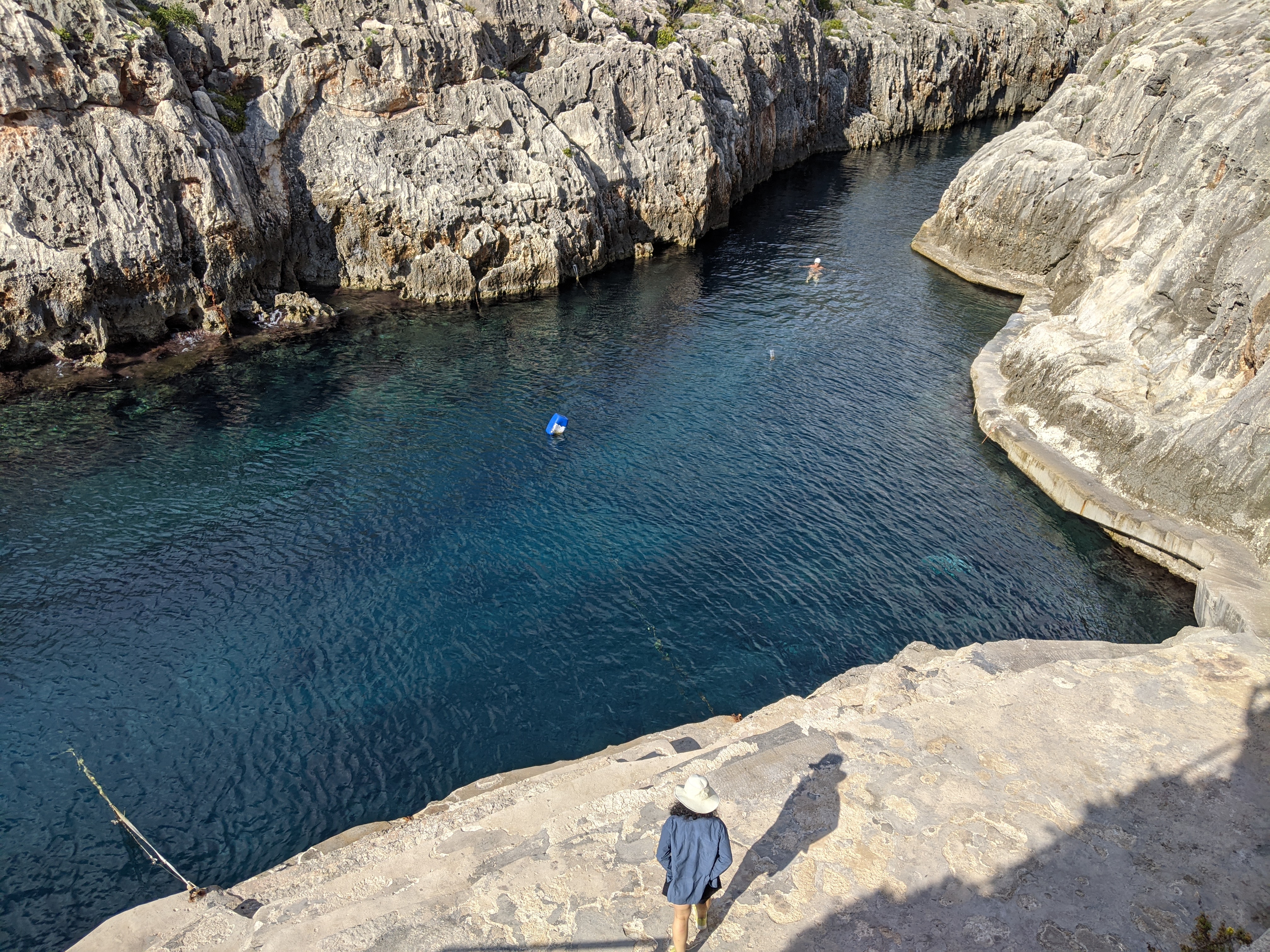Rocky swimming cove with dark blue water in Malta