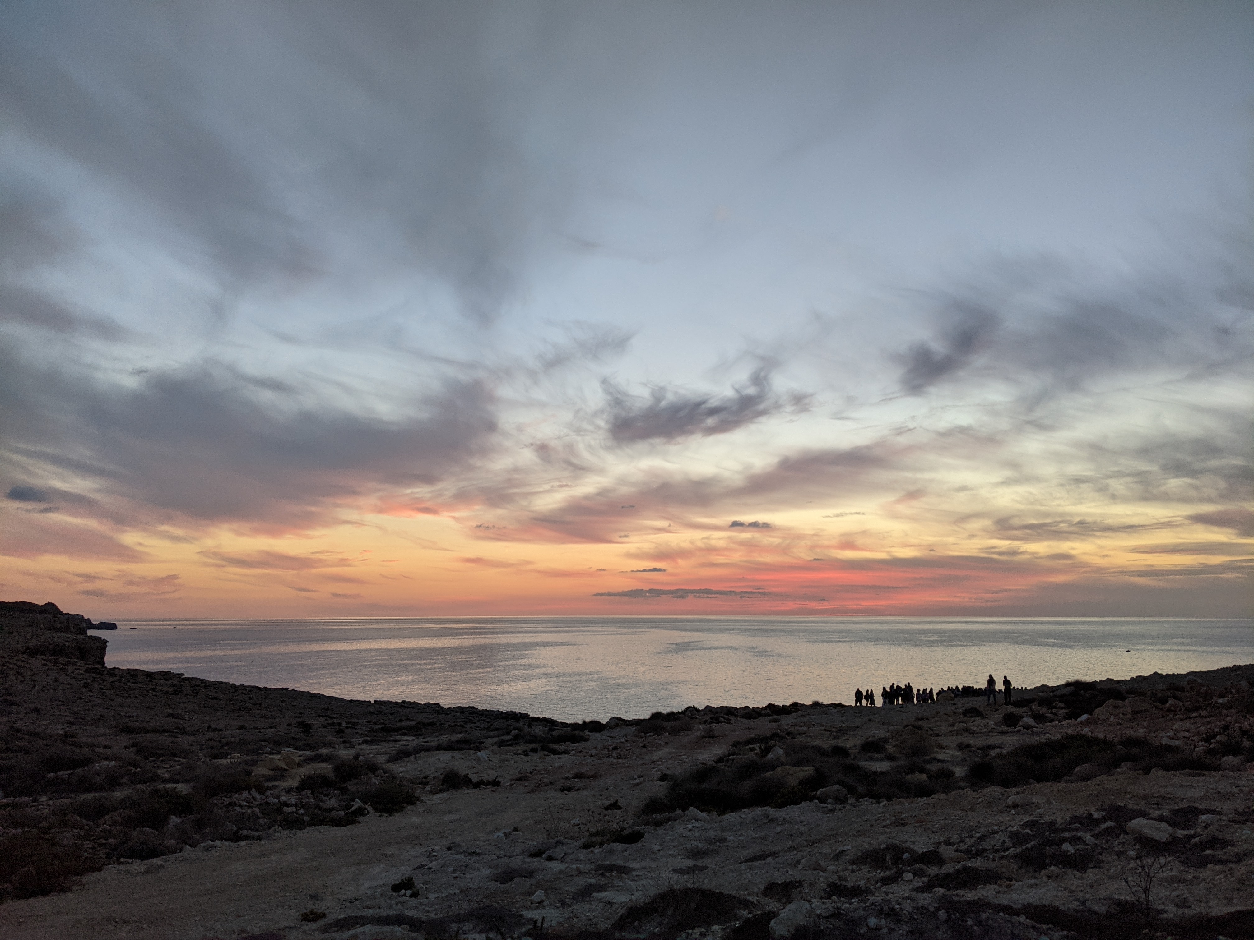 Sunset over the sea from Malta's rocky coastline